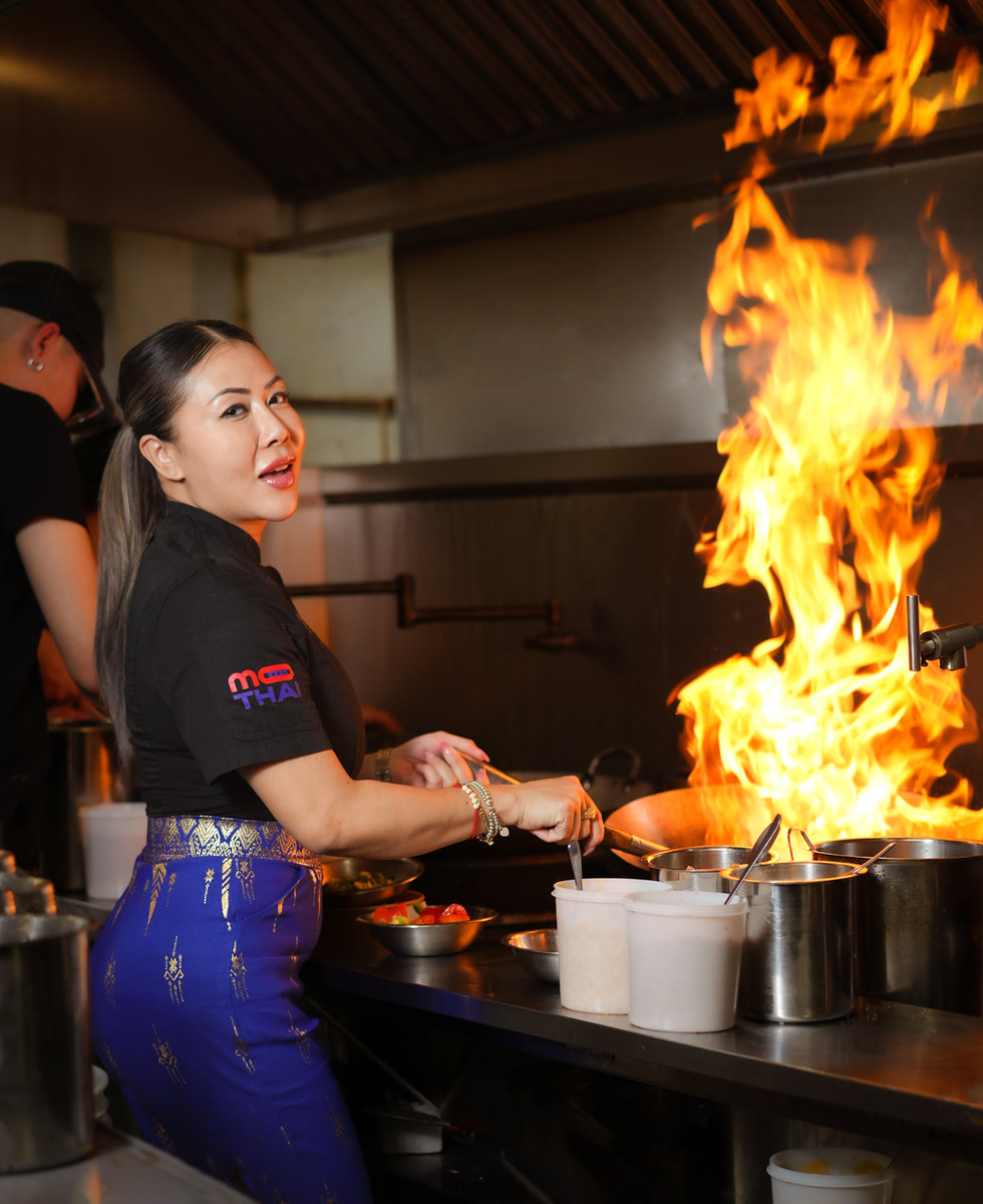 Chef Mo cooking over a flaming wok in the More Thai kitchen